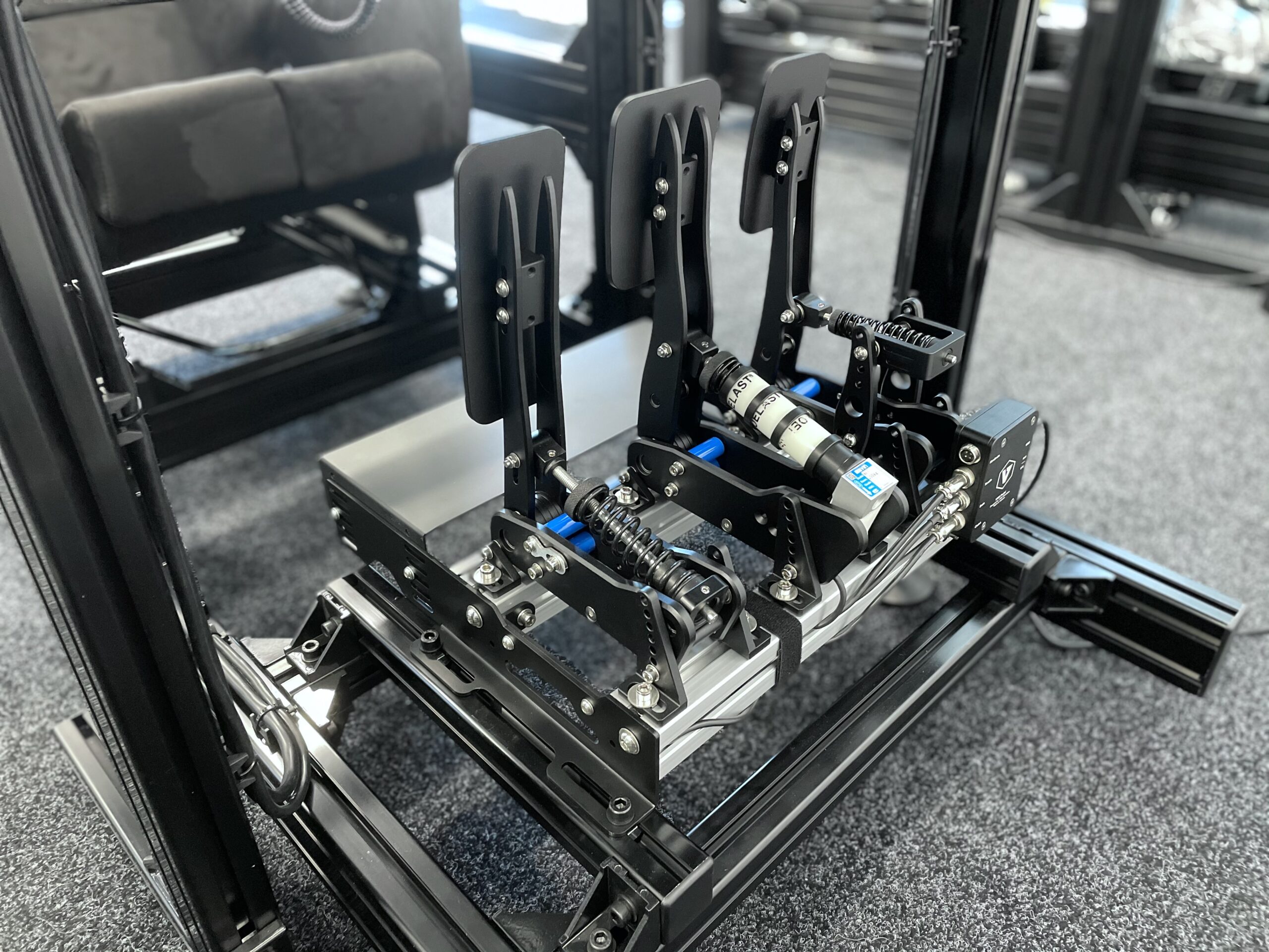 Pédalier de simracing avec réglage par élastomères, monté sur un rig